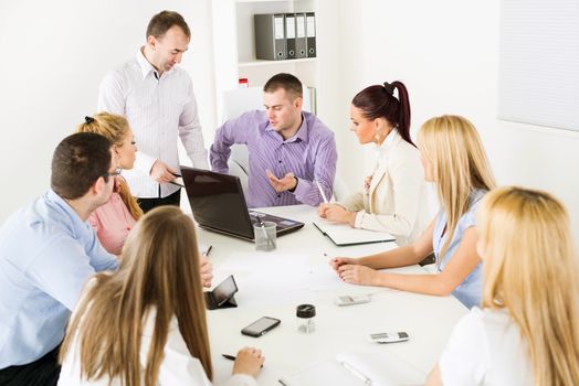 Happy Business people in the office discussing project on laptop at meeting.