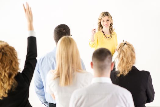 Friendly business woman explaining plan of work and answering the question. The team is listening and asking the questions.