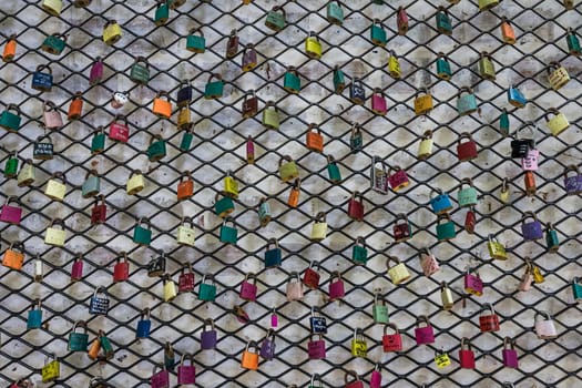 A shot of colorful locks on a fence.