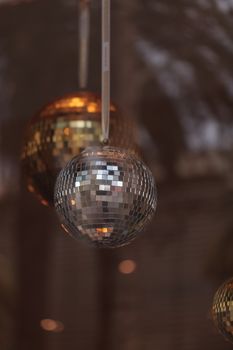 Silver and gold disco balls hang from the ceiling on New Years eve