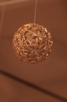 Gold silver Christmas ornament hanging from the ceiling in December