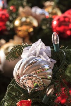 Red, green, gold, silver Christmas ornaments hanging on a Christmas tree in December