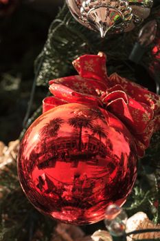 Red, green, gold, silver Christmas ornaments hanging on a Christmas tree in December