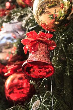 Red, green, gold, silver Christmas ornaments hanging on a Christmas tree in December