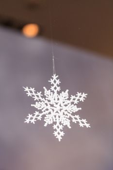 Gold silver Christmas ornament hanging from the ceiling in December