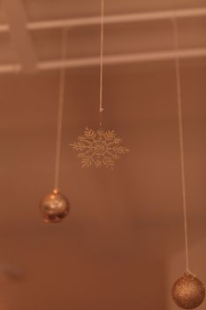 Gold silver Christmas ornament hanging from the ceiling in December