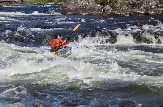 Kayaker in the  whitewater of a river Umba in Russia