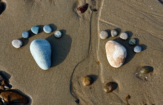 Group of foot by pebble on sand background, amazing concept from stone  with yellow color on beach, awesome art product