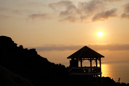 Silhouette of watch tower and people in morning at Dai Lanh cape, Mui Dien, Phu Yen, Viet Nam, yellow sun in sunrise make beautiful scene, this place catch the first sunlight in Vietnam country 