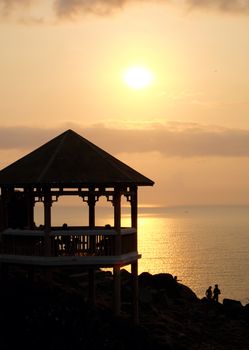 Silhouette of watch tower and people in morning at Dai Lanh cape, Mui Dien, Phu Yen, Viet Nam, yellow sun in sunrise make beautiful scene, this place catch the first sunlight in Vietnam country 
