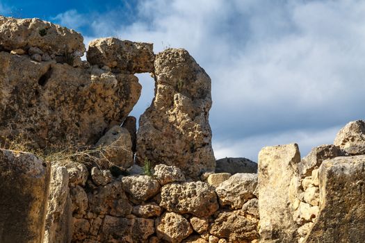View of stone structures of ancient Ggantija Temples in Gozo Malta, on cloudy blue sky background.