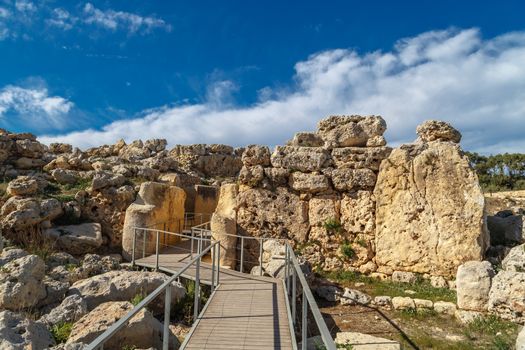 View of stone structures of ancient Ggantija Temples in Gozo Malta, on cloudy blue sky background.
