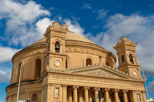 MOSTA, MALTA - NOVEMBER 1, 2015 : Exterior view of Rotunda of Malta known as also Mosta Dome, historical and the third biggest church in Europe, on cloudy blue sky background.