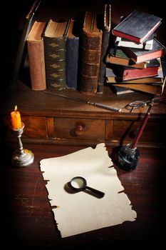 Pile of the old books and a magnifier