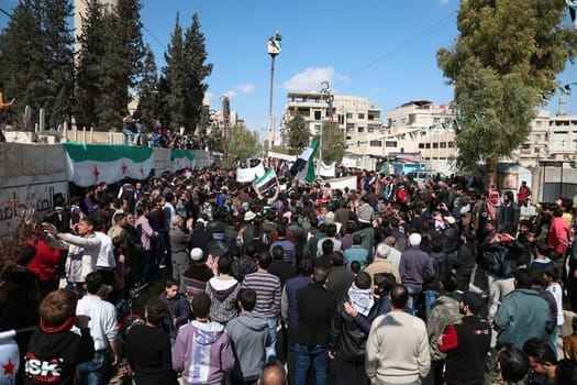SYRIA, Saqba: Protesters hold pre-Baath Syrian flags, adopted during the uprising in 2011, and placards during an anti-regime demonstration in the rebel-held town of Saqba, on the outskirts of the Syrian capital Damascus, on March 18, 2016. Syria's war is entering its sixth year with a glimmer of hope that a landmark ceasefire and a push for peace could help resolve a conflict that has sent hundreds of thousands fleeing to Europe. The conflict began with anti-regime protests in mid-March 2011 and spiralled into a bloody war after a harsh government crackdown on demonstrators.