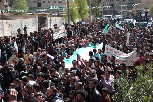 SYRIA, Saqba: Protesters hold pre-Baath Syrian flags, adopted during the uprising in 2011, and placards during an anti-regime demonstration in the rebel-held town of Saqba, on the outskirts of the Syrian capital Damascus, on March 18, 2016. Syria's war is entering its sixth year with a glimmer of hope that a landmark ceasefire and a push for peace could help resolve a conflict that has sent hundreds of thousands fleeing to Europe. The conflict began with anti-regime protests in mid-March 2011 and spiralled into a bloody war after a harsh government crackdown on demonstrators.
