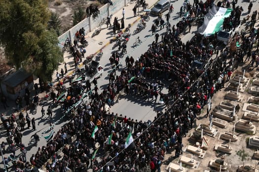 SYRIA, Saqba: Protesters hold pre-Baath Syrian flags, adopted during the uprising in 2011, and placards during an anti-regime demonstration along cemetery of the rebel-held town of Saqba, on the outskirts of the Syrian capital Damascus, on March 18, 2016. Syria's war is entering its sixth year with a glimmer of hope that a landmark ceasefire and a push for peace could help resolve a conflict that has sent hundreds of thousands fleeing to Europe. The conflict began with anti-regime protests in mid-March 2011 and spiralled into a bloody war after a harsh government crackdown on demonstrators.