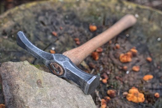 Hand made blacksmith hammer resting on an old stump