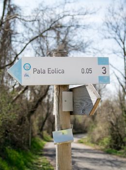 Wooden road sign indicating the direction to a wind farm.
