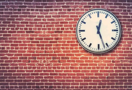 Retro Railway Style Clock Against A Red Brick Wall