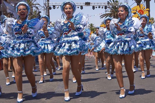 Female members of a Caporales dance group in ornate costumes performing at the annual Carnaval Andino con la Fuerza del Sol in Arica, Chile.