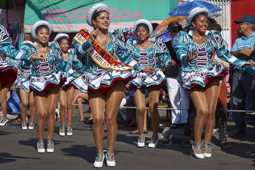 Female members of a Caporales dance group in ornate costumes performing at the annual Carnaval Andino con la Fuerza del Sol in Arica, Chile.