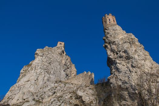 Castle Devin built on the high rocks on the border of Slovakia and Austria. On the left famous Maiden Tower. Bright blue sky.