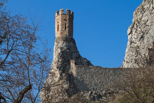 Rocks of the former fortress with a Maiden Tower, part of ruins of castle Devin in Slovakia. Bright blue sky.