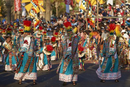 Tinku dancing group in colourful costumes performing a traditional ritual dance as part of the Carnaval Andino con la Fuerza del Sol in Arica, Chile.