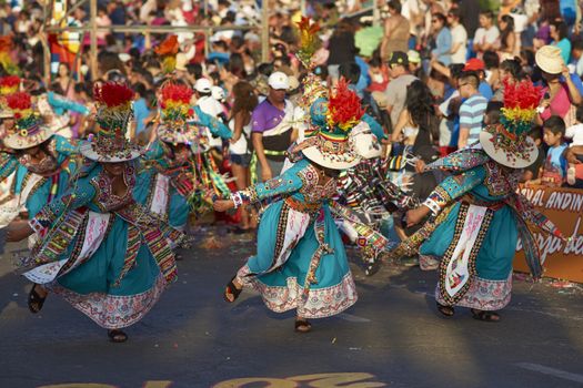 Tinku dancing group in colourful costumes performing a traditional ritual dance as part of the Carnaval Andino con la Fuerza del Sol in Arica, Chile.