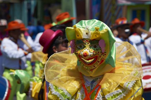 Masked dancer in colourful masked costume performing at the annual Carnaval Andino con la Fuerza del Sol in Arica, Chile.