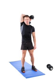 Young man shows starting position of Standing Triceps Extension Dumbbell behind head workout, isolated on white