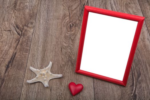 White starfish, heart and photo frame on a brown wooden background