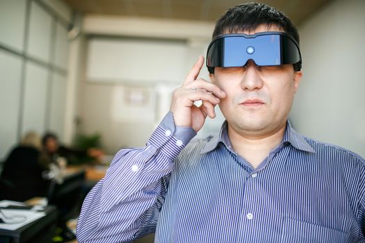 Business man in virtual reality glasses inside office