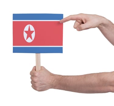 Hand holding small card, isolated on white - Flag of North Korea