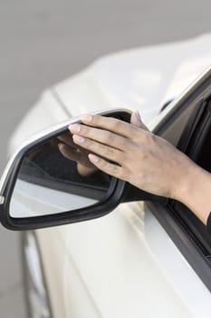 girl adjusts the rearview mirror