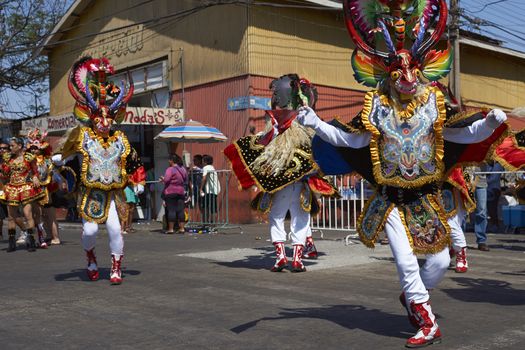 Masked members of a Diablada dance group performing as part of the Carnaval Andino con la Fuerza del Sol in Arica, Chile. The dance originates in Oruro, Bolivia.