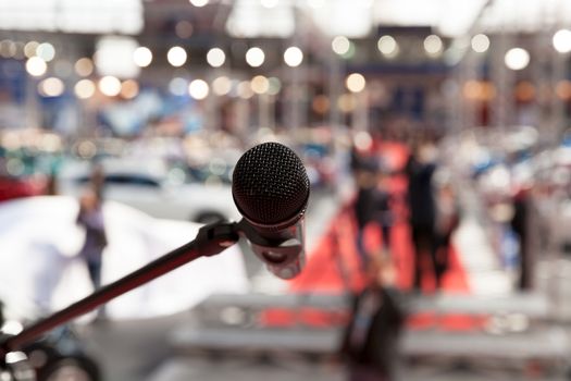 Microphone in focus against blurred audience