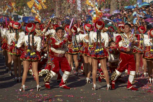 Caporales dance group in ornate red and white costumes performing at the annual Carnaval Andino con la Fuerza del Sol in Arica, Chile.