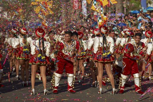 Caporales dance group in ornate red and white costumes performing at the annual Carnaval Andino con la Fuerza del Sol in Arica, Chile.