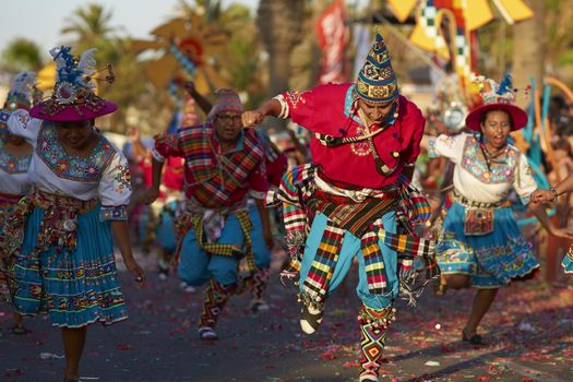 Tinku dancing group in colourful costumes performing a traditional ritual dance as part of the Carnaval Andino con la Fuerza del Sol in Arica, Chile.