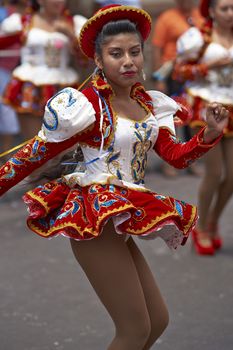 Caporales dancer in ornate red and white costume performing at the annual Carnaval Andino con la Fuerza del Sol in Arica, Chile.