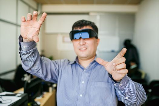 The man with glasses of virtual reality gesturing with his hands in front of him