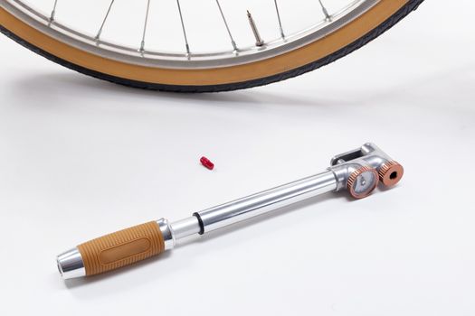 Composition with vintage stilysh bicycle pump and wheel, isolated on white.