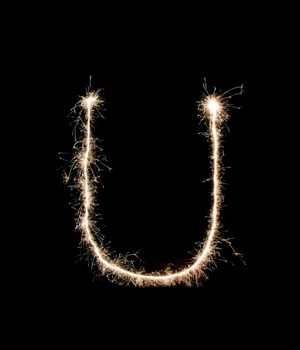 Letter U drew with spakrs on a black background.