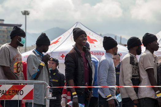 ITALY, Palermo: Migrants line up after getting off a ship in Palermo, Italy on March 19, 2016.712 migrants have arrived at the port of Palermo, on the military Norwegian ship Siem Pilot on March 19, 2016. Among them 598 men, 51 women, and 63 children came from 30 different nationalities including Nigeria, Senegal, Guinea, Sierra Leone and other Sub-saharan countries.
