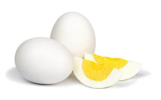 Two whole unpeeled boiled eggs and two slices of eggs isolated on a white background.