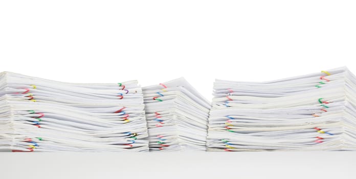 Overload of paperwork with colorful paperclip on white table and isolated on white background.