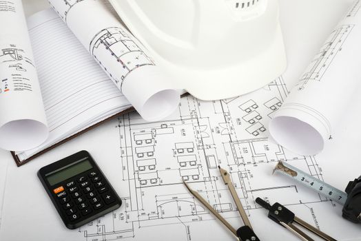Architecture plan and rolls of blueprints with hard hat and calculator. Building concept