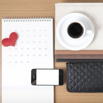 office desk : coffee with phone,wallet,calendar,heart,stack of book on wood background